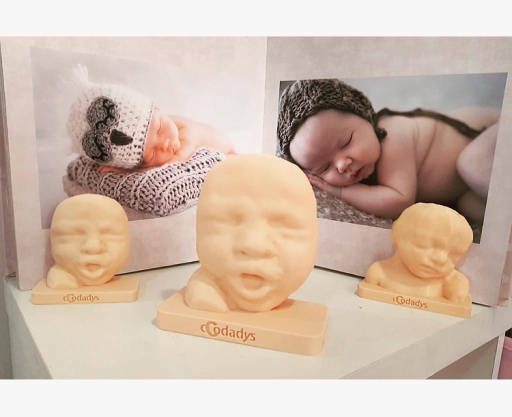 Impresiones 3D de Ecodadys con fotos de bebés en el fondo
