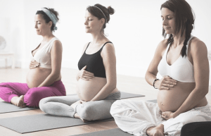 Embarazadas haciendo yoga y respirando profundamente